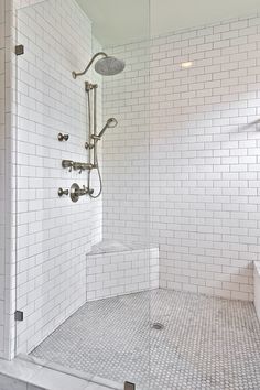 a white tiled bathroom with a walk in shower