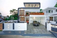 a car is parked in front of a modern house with white walls and windows on the second floor