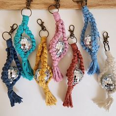 several different colored key chains with disco balls on one end and tassels on the other