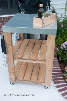 an outdoor kitchen cart made out of pallet wood and metal with wine bottles on top