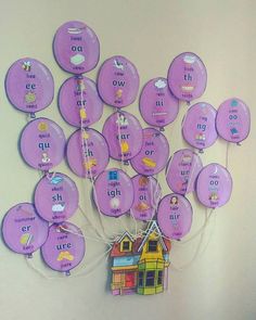 a group of purple balloons with words written on them hanging from the side of a wall