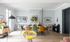 a living room filled with lots of furniture and pictures on the wall next to a piano