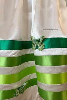 two green and white striped curtains with butterfly appliqued on the side,