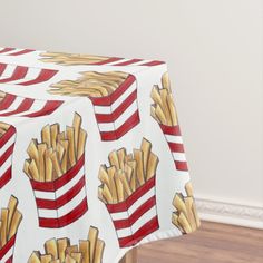 a red and white table cloth with french fries on it in front of a wall