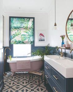 the bathroom is decorated in shades of blue and white, with an oval mirror above the bathtub