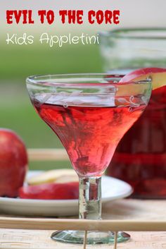 an apple cider sitting on top of a wooden table next to some glasses filled with liquid