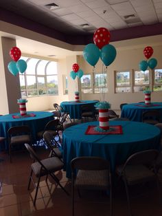 tables and chairs are set up with blue tablecloths, red and white balloons, and polka dot centerpieces