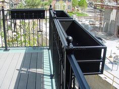 a balcony with black railing and wooden decking