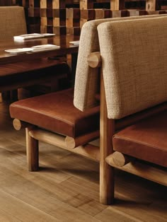 two brown chairs sitting next to each other on top of a wooden floor