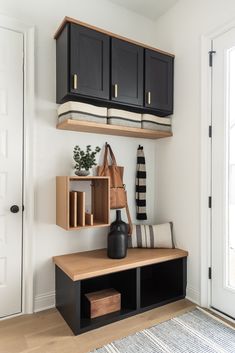 the entryway is clean and organized with black cabinetry, bookshelves, and a striped rug