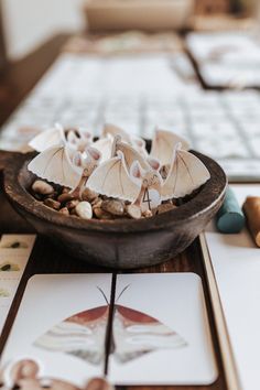 a bowl filled with shells on top of a table next to cards and a keyboard