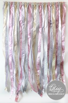 some pink, silver and gold streamers hanging from a wall