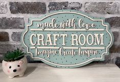 a sign that reads made with love craft room, imagine create inspire next to a potted succulent