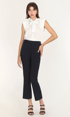 This sleeveless blouse was created for both tailored and casual looks. A modified version of the Edna Neck Tie Blouse, this high-collared piece can still be tied and styled in multiple ways. The tank top feel is comfortable and suitable for adjusting easily between formal and informal meetings. Wearing a blazer or coat over feels even easier without having to adjust sleeves to match. Tie bow blouse Sleeveless Satin Cotton Imported 100% Polyester Length: 24" Chest: 20 1/4" Hand wash in cold water Chic Stretch Blouse For Work, Chic Stretch Blouse For Business Casual, Sleeveless Business Casual Blouse, Sleeveless Blouse For Business Casual, Chic Sleeveless Blouse For Office, Chic Sleeveless Office Blouse, Fitted Tie Neck Top For Workwear, Classic Sleeveless Blouse For Work, Sleeveless Summer Office Tops