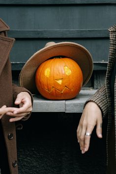 a person wearing a hat next to a pumpkin