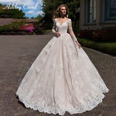 a woman in a wedding dress standing on a cobblestone road with her hands behind her back