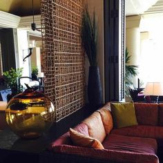 a living room filled with furniture next to a large mirror and vase on top of a table