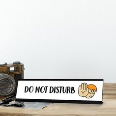 a sign that says do not disturb on it next to an old camera