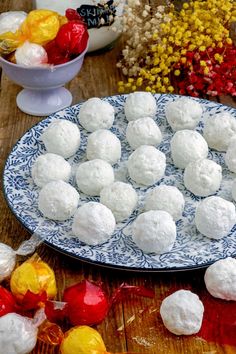 a plate full of snowballs sitting on top of a wooden table next to candy