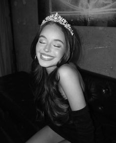 a woman wearing a tiara sitting on a couch