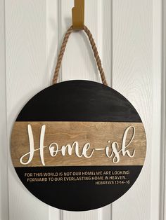 a wooden sign that says home - ish hanging on a door with a rope