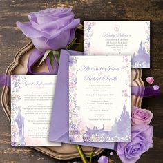 the wedding stationery is displayed on a plate with purple flowers and ribbon around it