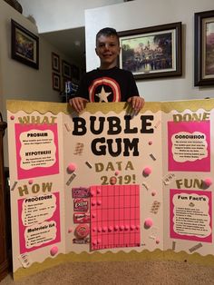 a young man holding up a bulletin board that says bubble gum data 2019 on it