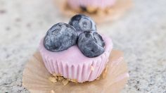 three blueberries are sitting on top of a cupcake