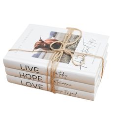 three books wrapped in twine and tied with a brown ribbon on each book cover