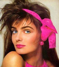 a close up of a person wearing a pink dress and with a bow in her hair