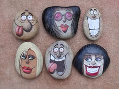 five painted rocks with different faces on them