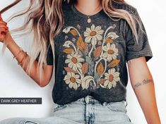 Wildflower TShirt Vintage Inspired Boho Retro Graphic Tee Botanical  Flower Shirt Art Deco Floral  Retro Band Colorful Nouveau Look T-Shirt Band Style  Womans Gift  -------------------------------------------------- Boho Wildflower vintage-inspired graphic tee that takes inspiration from retro band shirts featuring Art Nouveau organic stylings.  This botanical tee is a must-have for anyone who loves the unique mix of vintage and boho styles.  The design showcases a retro color palette, with bold Bohemian Floral Print T-shirt With Relaxed Fit, Bohemian Floral Print Relaxed Fit T-shirt, Hippie Cotton Tops With Floral Print, Hippie Floral Print Crew Neck Top, Hippie Cotton Top With Floral Print, Bohemian Short Sleeve Tops With Custom Print, Rose Ideas, Boho Wildflower, Retro Color Palette