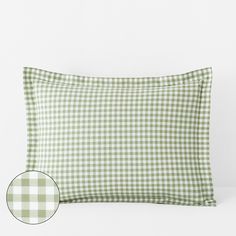 a green and white gingham checkered pillow case on a white background with a round button