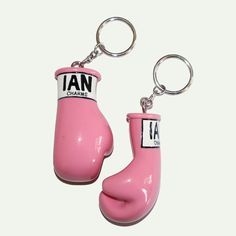 two pink rubber boots are attached to key chains with the words ian on them