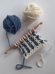 two skeins of yarn next to each other on a white surface with blue and white crochet