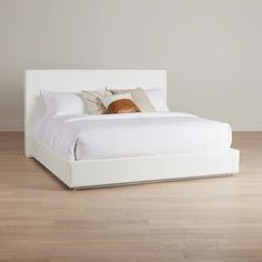 a white bed sitting on top of a hard wood floor