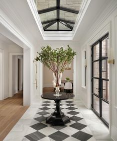 a black and white checkered floor with a vase filled with flowers on the table