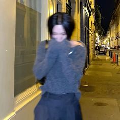 a woman is walking down the street talking on her cell phone while wearing a blue dress