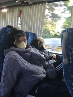 a woman wearing a face mask while sitting on a bus