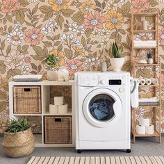 a washer and dryer sitting next to each other in front of a floral wallpaper