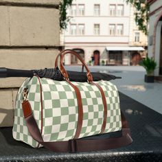 "Travel in Style with Our Green Checkered Pattern Weekend Duffel Bag - Your Perfect Getaway Companion! Embark on unforgettable weekend adventures with our Checkered Pattern Weekend Duffel Bag, a delightful blend of fashion and functionality that allows you to travel in style without compromising on practicality. Key Features: Chic and Vibrant Design: Our duffel bag features a chic and vibrant checker pattern that sets you apart from the crowd. The beautiful blooms add a touch of elegance to your travel ensemble, making it a statement piece that exudes charm. Spacious and Versatile: With a generous interior, this duffel bag offers ample space to pack your clothing, essentials, and travel necessities for a weekend getaway. It's the perfect companion for short trips or as a carry-on bag for l Trendy Green Travel Bag With Large Capacity, Green Large Capacity Trendy Travel Bag, Trendy Large Capacity Green Travel Bag, Trendy Rectangular Travel Bag For Outdoor, Green Square Travel Bag, Green Shoulder Duffle Bag For Travel, Green Bag With Luggage Sleeve For Outdoor, Green Large Capacity Shoulder Bag For Trip, Green Shoulder Bag For Trip With Large Capacity