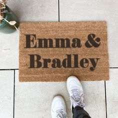 a person standing in front of a door mat that says,'edna & bradley '