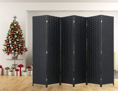 a room divider in front of a christmas tree with presents on the floor next to it