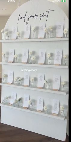 there is a display with cards and flowers on the wall next to each other that says find your seat