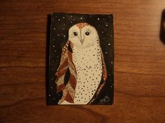 an owl painted on a piece of wood next to a computer mouse