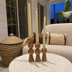 two candles are placed on a table in front of a couch