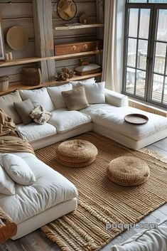 a large white couch sitting in front of a window next to a wooden shelf filled with baskets