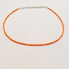 This beautiful necklace is handmade with dainty orange seed beads. It comes in a variety of lengths (14, 16, 18, 20, 22, or 24 inches) ranging from a choker fit to a longer necklace. Each necklace also comes with additional extender chain, making the necklace easily adjustable! The orange color is perfect for fall and Halloween and goes well with so many different outfits! Orange Necklaces With Tiny Beads For Gift, Orange Tiny Beads Necklace For Gift, Adjustable Orange Beaded Necklaces With Tiny Beads, Adjustable Orange Beaded Necklace With Tiny Beads, Adjustable Orange Choker Jewelry, Orange Tiny Beads Choker Necklace, Orange Beaded Choker With Tiny Beads, Orange Beaded Choker With Round Beads, Orange Beaded Choker Jewelry