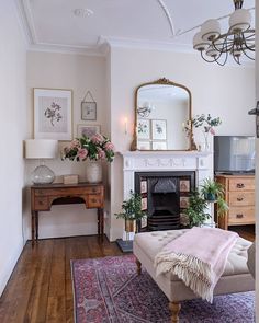 a living room filled with furniture and a fire place next to a mirror on the wall