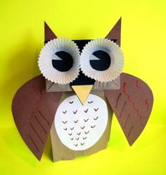 an owl made out of paper on a yellow background